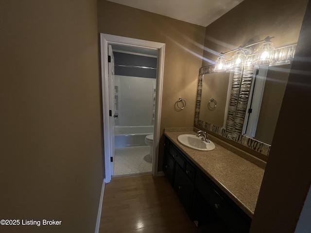 full bath with toilet, vanity, bathtub / shower combination, and wood finished floors