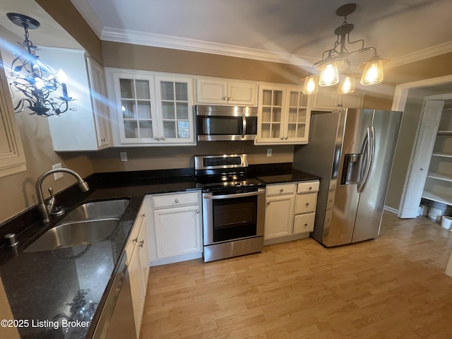 kitchen with ornamental molding, appliances with stainless steel finishes, light wood-style floors, and a sink