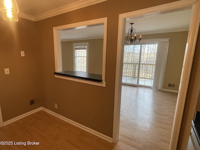 interior space with crown molding, a notable chandelier, a healthy amount of sunlight, and visible vents