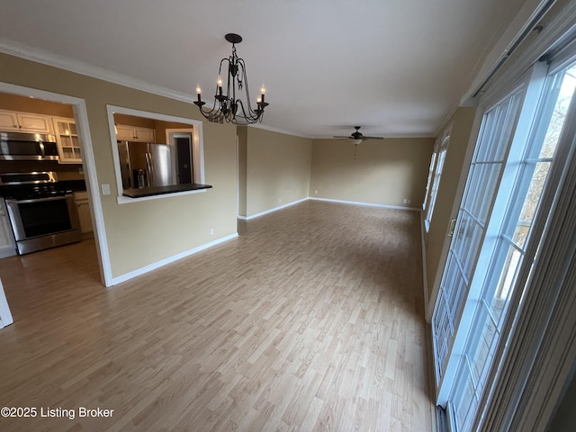 unfurnished room with ornamental molding, ceiling fan with notable chandelier, light wood-style floors, and baseboards