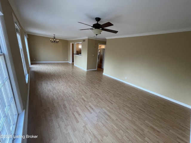 unfurnished room with light wood-style floors, ceiling fan with notable chandelier, baseboards, and ornamental molding