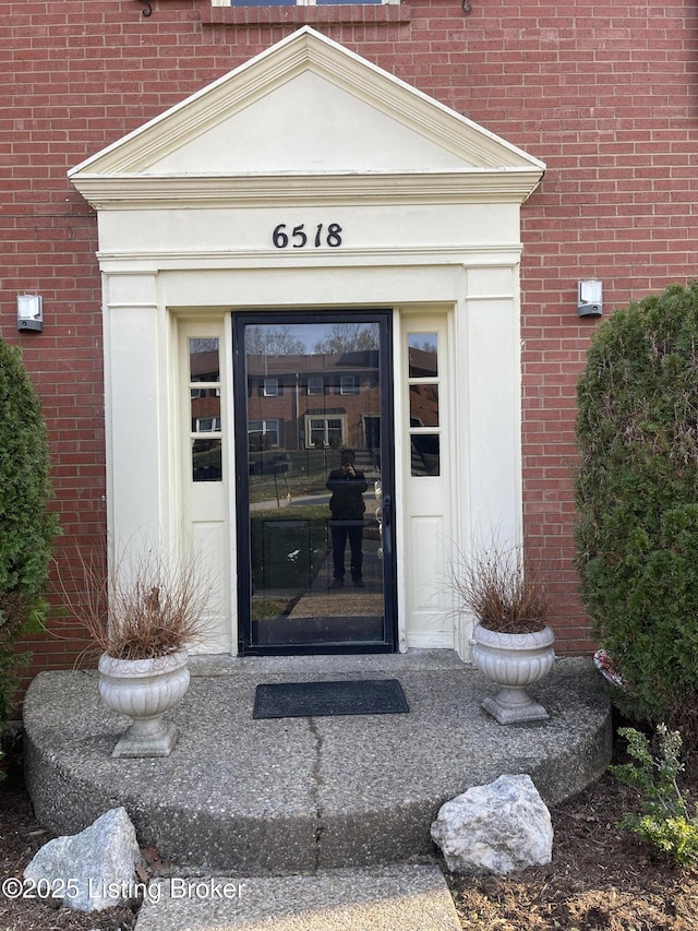 view of exterior entry with brick siding