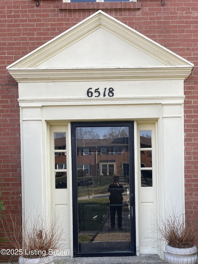 doorway to property featuring brick siding