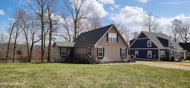 view of front of home with entry steps, a front yard, and a shingled roof