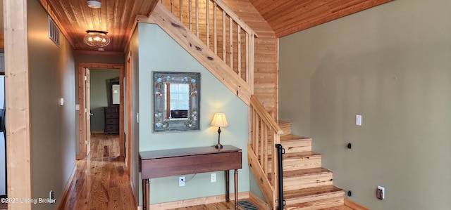 staircase with visible vents, wood finished floors, and wooden ceiling