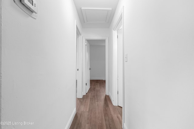 hall featuring baseboards and wood finished floors