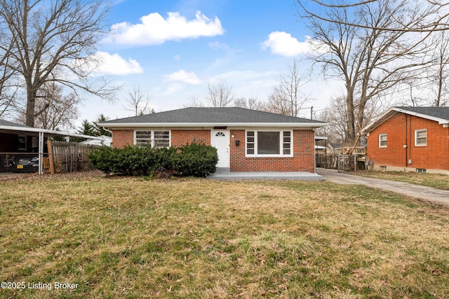 view of front facade with brick siding, a front yard, and fence