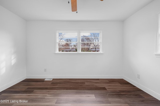 unfurnished room featuring baseboards, wood finished floors, visible vents, and ceiling fan