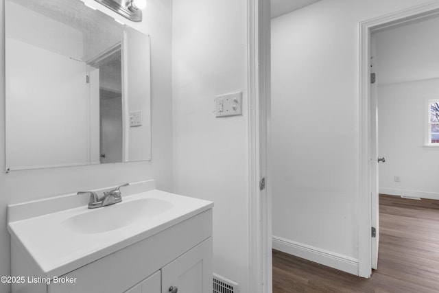 bathroom with visible vents, baseboards, wood finished floors, and vanity