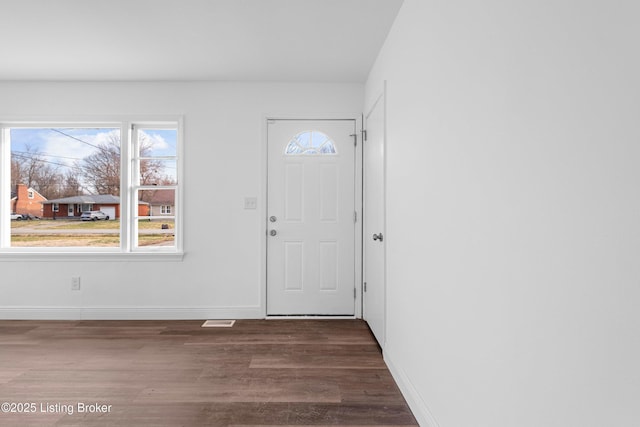 entrance foyer with dark wood-style floors and baseboards