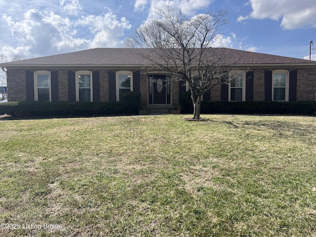 ranch-style house with brick siding, roof with shingles, and a front yard