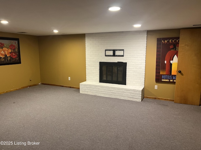 unfurnished living room with a brick fireplace, carpet flooring, and recessed lighting