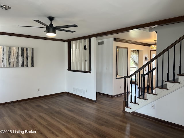 unfurnished room featuring visible vents, wood finished floors, stairs, and ceiling fan with notable chandelier