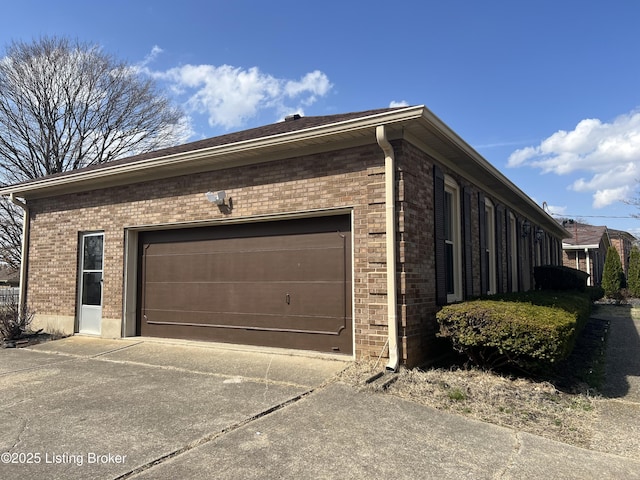 exterior space with a garage, brick siding, and driveway