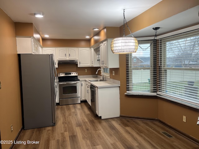 kitchen with visible vents, a sink, under cabinet range hood, appliances with stainless steel finishes, and white cabinetry