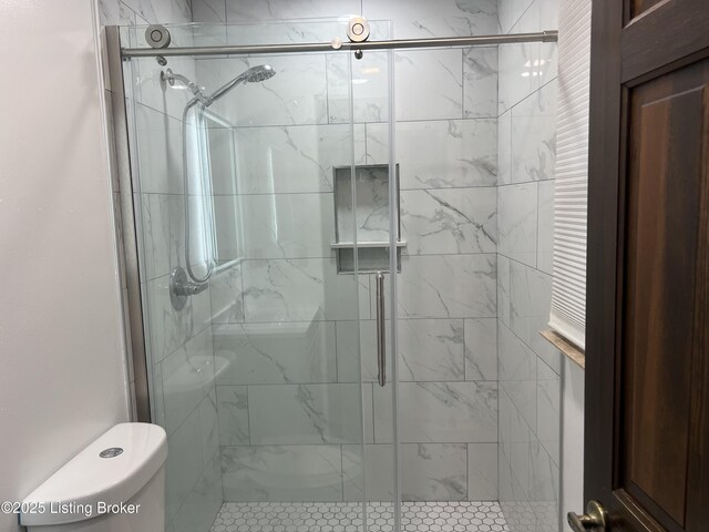 bathroom with toilet and a stall shower
