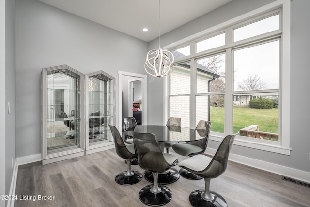 dining room featuring visible vents, baseboards, an inviting chandelier, and wood finished floors