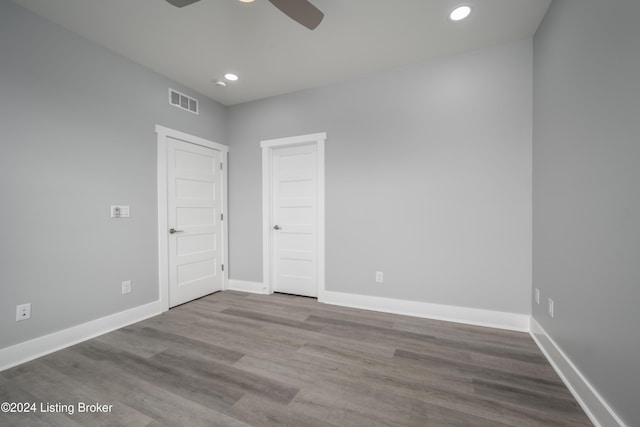 spare room featuring visible vents, wood finished floors, baseboards, and ceiling fan