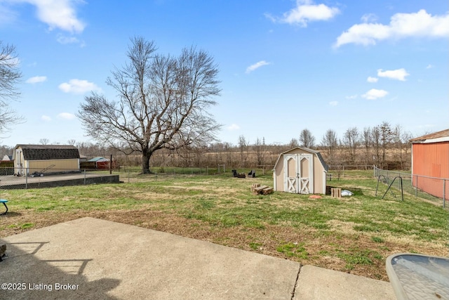 view of yard with an outdoor structure, fence, a shed, and a patio