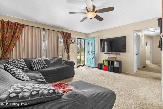 living area with a ceiling fan, carpet, and baseboards