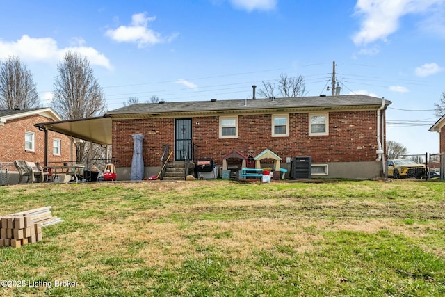 rear view of house featuring a lawn, entry steps, central AC, and fence