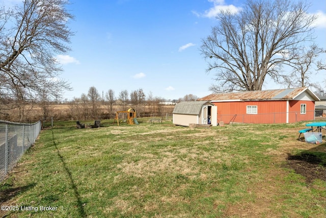 view of yard with fence, an outbuilding, and a playground