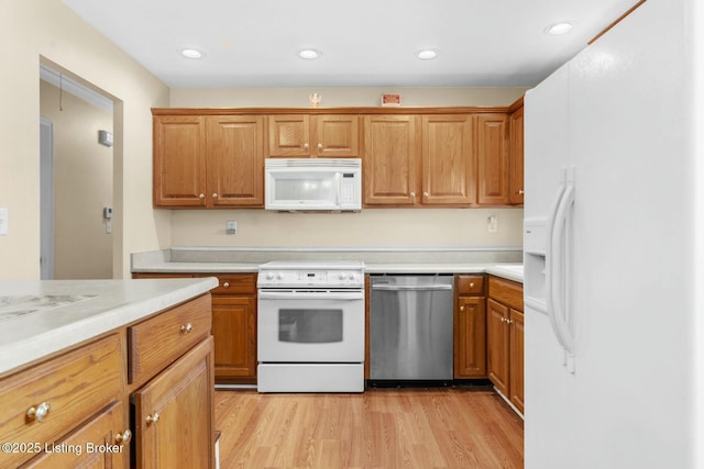 kitchen with white appliances, recessed lighting, light countertops, and light wood finished floors