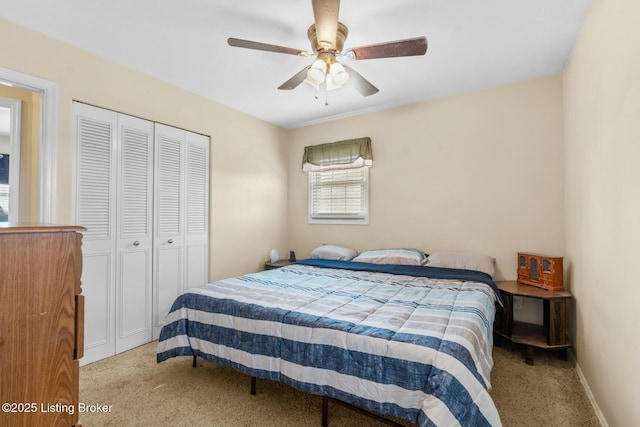 carpeted bedroom with a closet, baseboards, and a ceiling fan