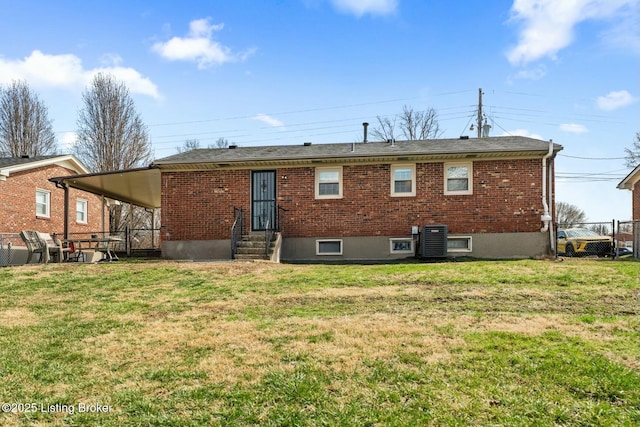 rear view of property with central air condition unit, entry steps, a yard, and fence