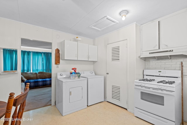 kitchen with washer and clothes dryer, under cabinet range hood, light floors, white gas range, and white cabinets