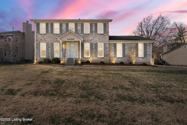 colonial home with a front lawn