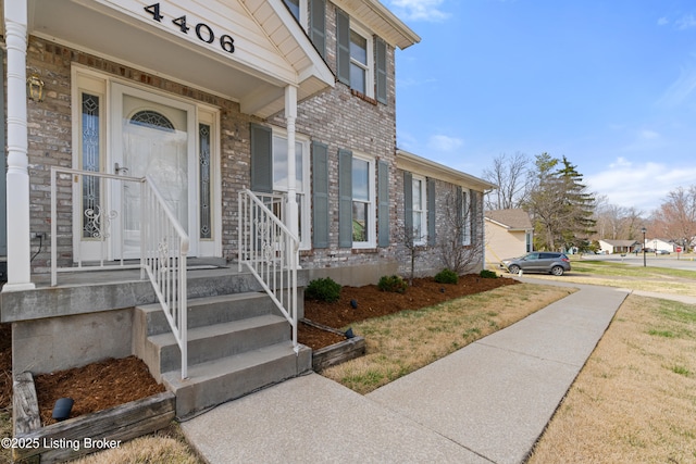 entrance to property featuring brick siding