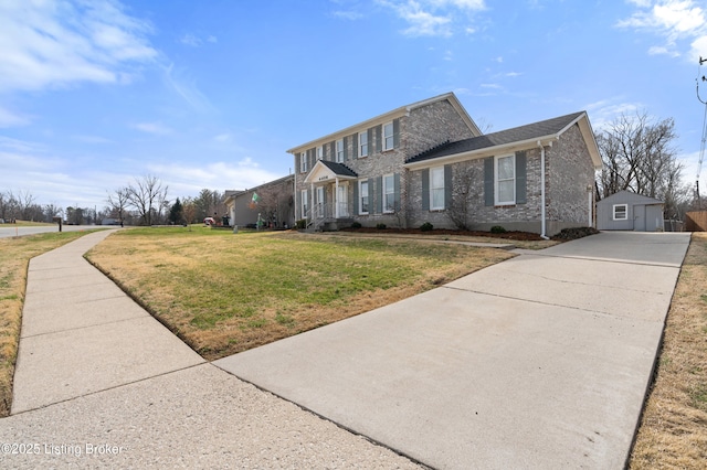 view of front of home with driveway, an outdoor structure, and a front yard