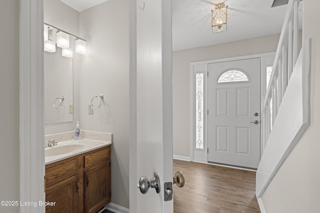 foyer with baseboards and wood finished floors