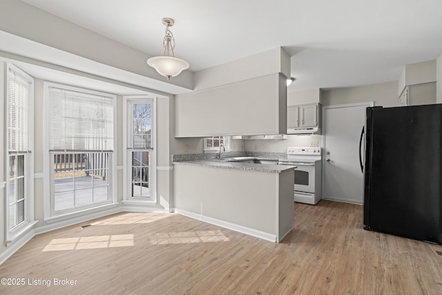 kitchen with white electric range oven, light wood finished floors, a peninsula, freestanding refrigerator, and gray cabinetry