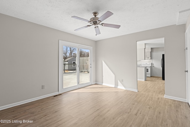 unfurnished living room featuring a ceiling fan, visible vents, baseboards, light wood-style floors, and a textured ceiling