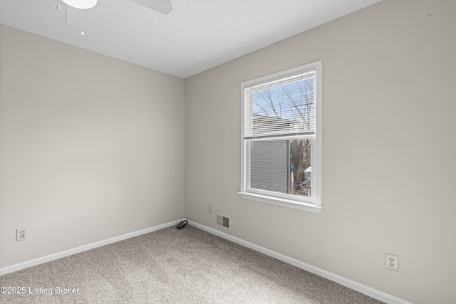 carpeted empty room with visible vents, a ceiling fan, and baseboards