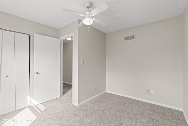 unfurnished bedroom with carpet, visible vents, a closet, and baseboards