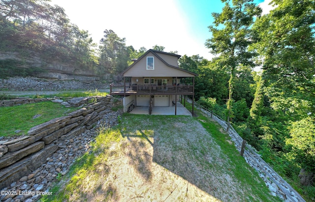 260 Patriots Path Ln, Falls Of Rough, KY 40119 - rear view of property with dirt driveway, a lawn, an attached garage, and a wooden deck