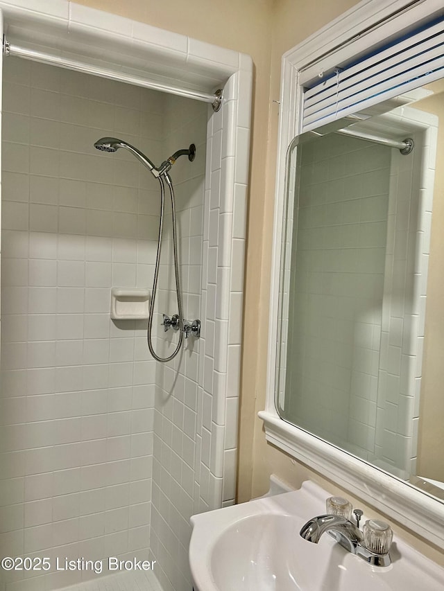 bathroom featuring a sink and tiled shower