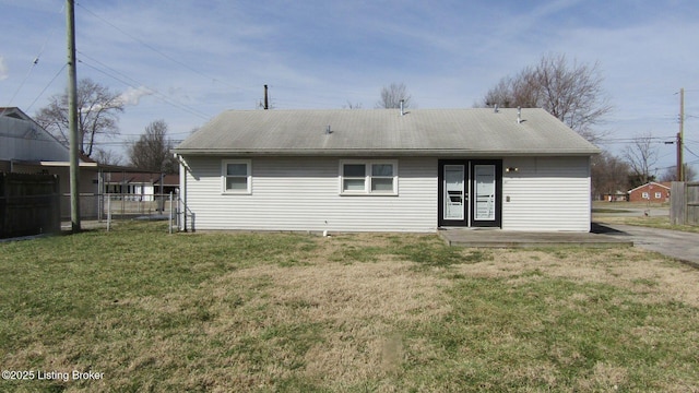 back of property with a yard and fence