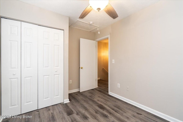 unfurnished bedroom featuring ceiling fan, wood finished floors, a closet, and baseboards