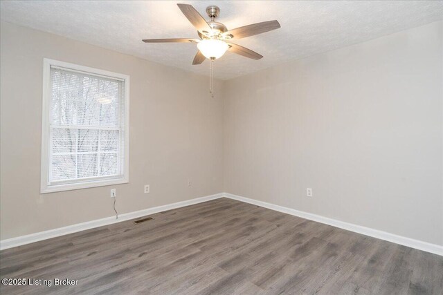 spare room with wood finished floors, visible vents, and a textured ceiling