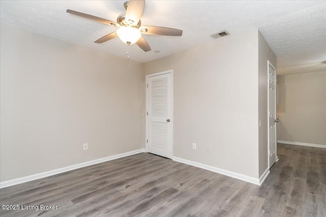 unfurnished room featuring ceiling fan, visible vents, and wood finished floors
