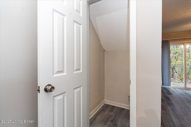 interior space featuring a textured ceiling, baseboards, and wood finished floors