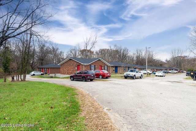 view of front of property featuring brick siding and a front yard