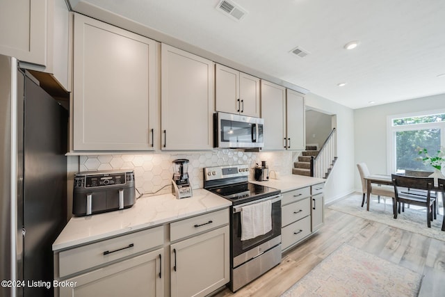 kitchen featuring visible vents, backsplash, and stainless steel appliances