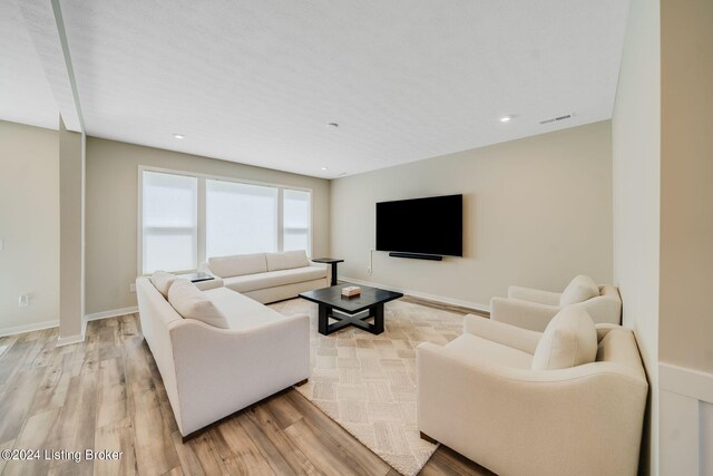 living room featuring light wood-style flooring, recessed lighting, baseboards, and visible vents