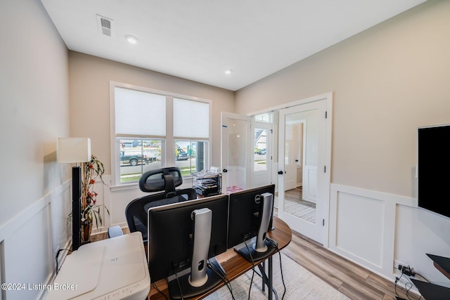 home office with light wood-type flooring, a wainscoted wall, visible vents, recessed lighting, and a decorative wall