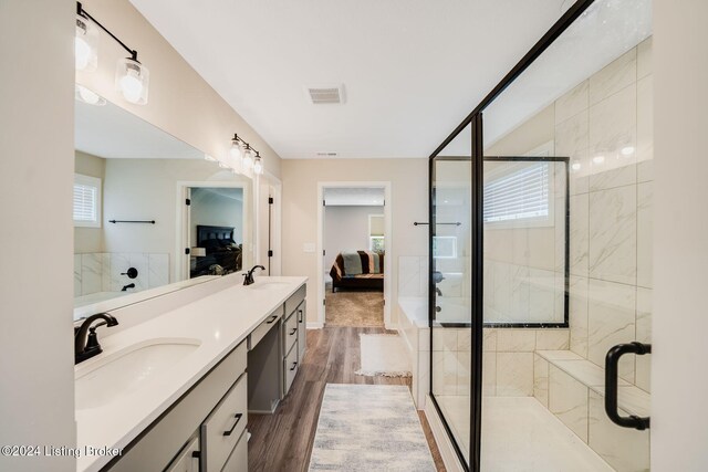full bathroom with visible vents, connected bathroom, a stall shower, and a sink